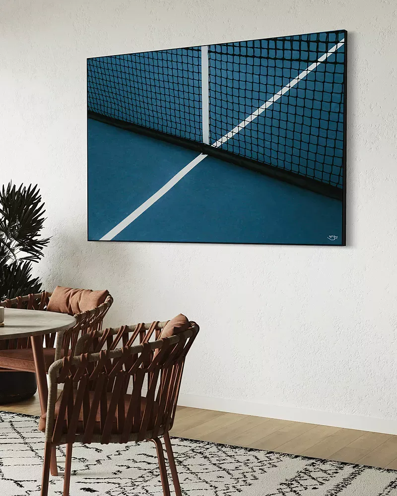 Oversized wall art of a tennis lover wall photograph canvas on the wall. The tennis net and court is visible