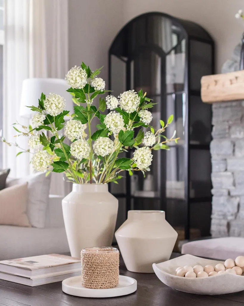White spray of wild hydrangeas in a white vace with a chic stylish home decor backgroun.
