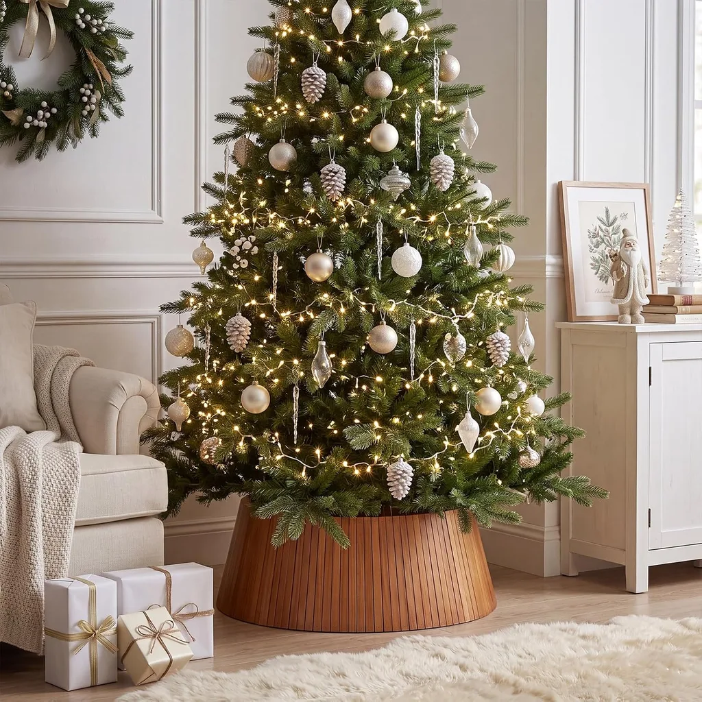 Beautiful Designer Christmas Decor Dupes You Can Buy or DIY – Neutral Christmas Tree with Wicker Collar

A full Christmas tree decorated with gold ornaments and warm twinkling lights stands in a neutral living room. A woven wicker collar conceals the tree stand, adding natural texture that complements the room's soft furnishings and understated holiday decor.