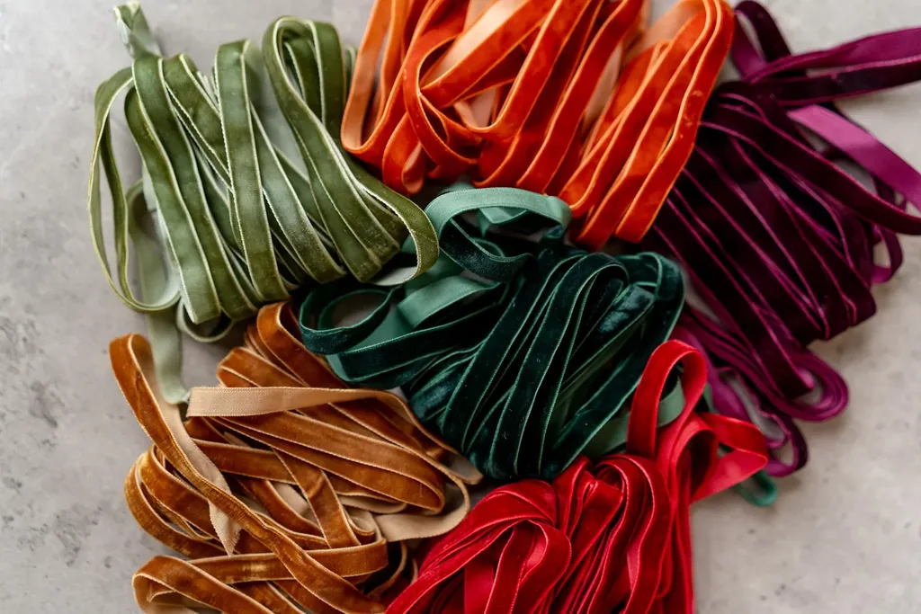 Beautiful Designer Christmas Decor Dupes You Can Buy or DIY – Colorful Velvet Christmas Ribbons

A collection of luxurious velvet ribbons in rich shades of emerald green, burgundy, red, orange, and gold is arranged in loose loops. Their soft texture and vibrant colors make them beautiful accents for Christmas trees, gift wrapping, wreaths, and festive holiday arrangements.