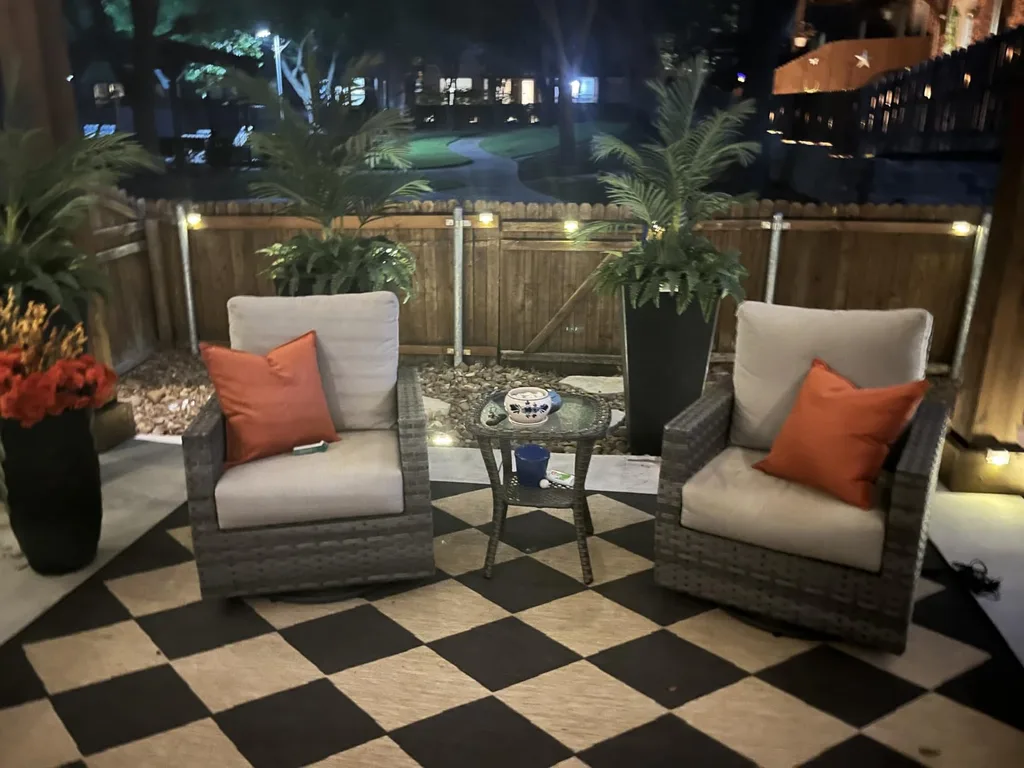 Easy Ways to Make Your Porch Feel Like Fall - Outdoor fall design with lighting, orange pillows.