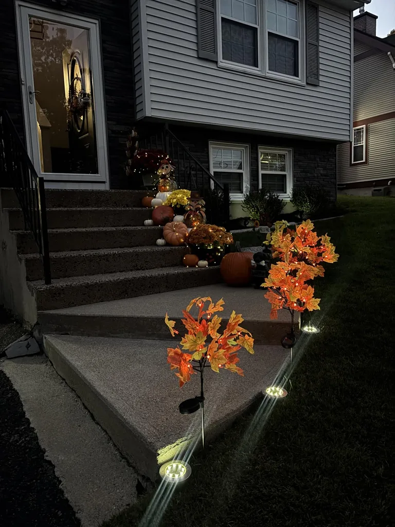 Easy Ways to Make Your Porch Feel Like Fall - Outdoor fall decors, patio pathway with fallen leaves lighting decorations and pumpkins.
