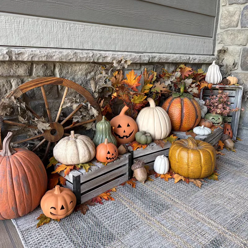 Easy Ways to Make Your Porch Feel Like Fall - Outdoor Seating with Evening Ambiance: A nighttime patio featuring two cushioned wicker chairs with rust-colored pillows, a small glass-top table, potted palms, and a black-and-white checkerboard floor for a relaxed outdoor retreat.