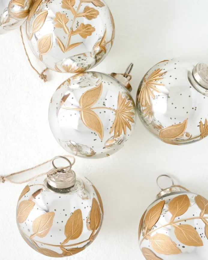 Beautiful Designer Christmas Decor Dupes You Can Buy or DIY – Gold Botanical Christmas Ornaments

Gold glass Christmas ornaments featuring delicate botanical leaf designs hang from lush evergreen branches. Their reflective finish and natural detailing create an elegant, timeless look for a sophisticated Christmas tree.