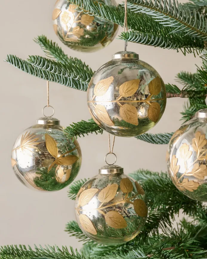 Beautiful Designer Christmas Decor Dupes You Can Buy or DIY – Gold Botanical Christmas Ornaments

Gold glass Christmas ornaments featuring delicate botanical leaf designs hang from lush evergreen branches. Their reflective finish and natural detailing create an elegant, timeless look for a sophisticated Christmas tree.